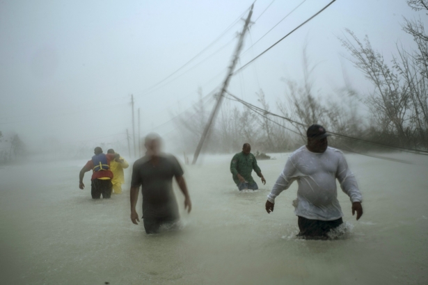 Volunteers walk under the wind and rain from Hurricane Dorian through a flooded road as they work to rescue families near the Causarina bridge in Freeport, Grand Bahama, Bahamas, on Sept. 3, 2019. (Ramon Espinosa/AP Photo)
