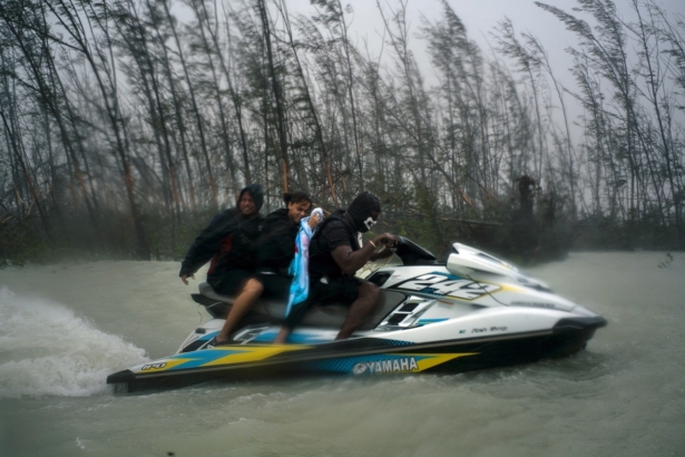 A woman who was trapped by flood waters during Hurricane Dorian is transported out of the area by volunteers on a jet ski near the Causarina bridge in Freeport, Grand Bahama, Bahamas, on Sept. 3, 2019. (Ramon Espinosa/AP Photo)