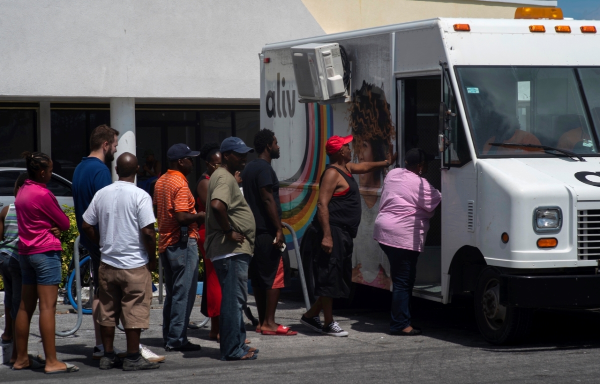 People line up to buy pre-paid cell phone cards, for sale from a mobile Aliv office, after the passing of Hurricane Dorian in Freeport, Bahamas, on Sept. 11, 2019. (Ramon Espinosa/AP Photo)