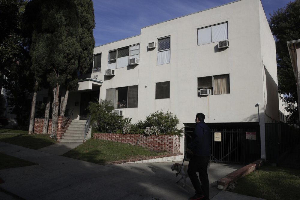 A man walks his dog past an apartment building where an unidentified man died in the apartment of Democratic Party donor Ed Buck, in West Hollywood, Calif., on Jan. 8, 2019. (Jae C. Hong/AP Photo)
