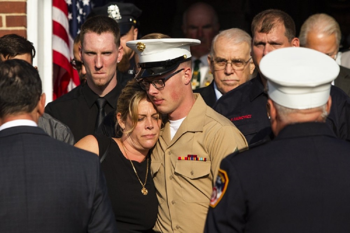 Erika Starke, left, is comforted by her son Michael Haub as they attend a second funeral service for New York Fire Department firefighter Michael Haub, in Franklin Square, N.Y., Sept. 10, 2019. (Eduardo Munoz Alvarez/AP Photo)