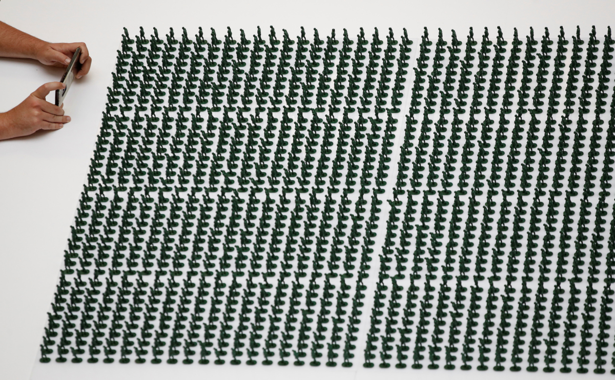 A man takes photographs of some of the 40,000 3D printed plastic figures on display as part of an installation by veterans charity Help for Heroes to highlight the number of veterans medically discharged from the armed forces over the last 20 years in Manchester, Britain on Oct. 7, 2019. (Phil Noble/Reuters)