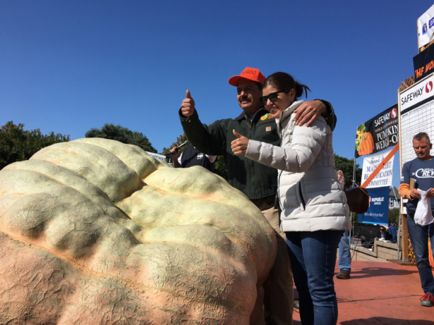 Leonardo Urena and his wife stand with their pumpkin after being declared winner for growing the biggest pumpkin at the Safeway World Championship Pumpkin Weigh-off in Half Moon Bay on Oct. 14, 2019. (Ilene Eng/NTD)