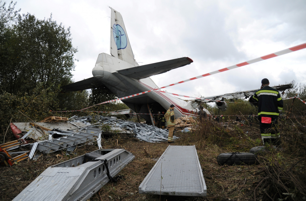 Members of emergency services work at the site of the Antonov-12 cargo airplane emergency landing in Lviv region, Ukraine on Oct. 4, 2019. (Mykola Tys/Reuters)