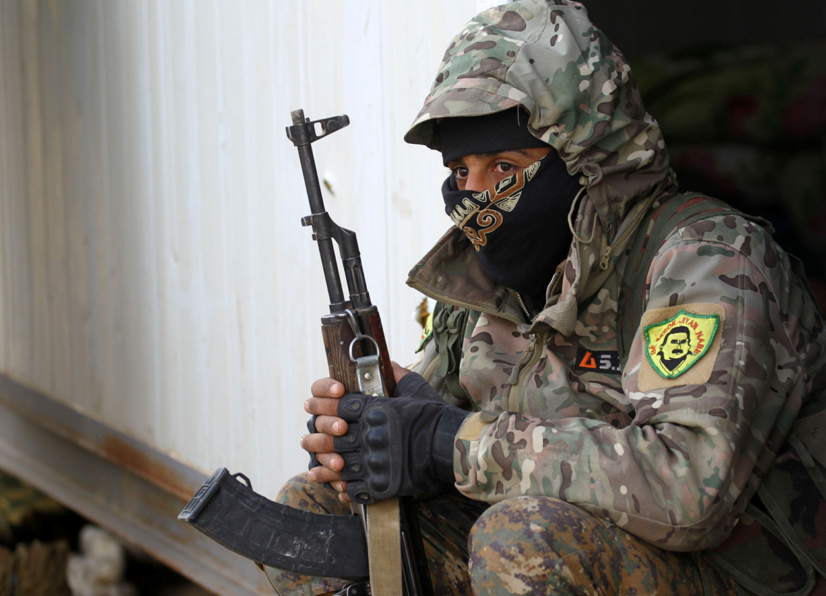 A fighter from the Syrian Democratic Forces (SDF) holds a weapon in the village of Baghouz, Deir Al Zor province, Syria, on March 17, 2019. (Stringer/Reuters)