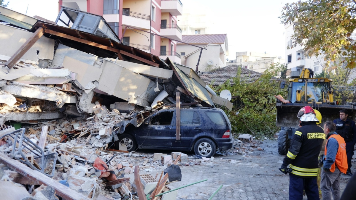 Firefighters stand next to a damaged building after a magnitude 6.4 earthquake in Durres, western Albania on Nov. 26, 2019. (Hektor Pustina/AP Photo)