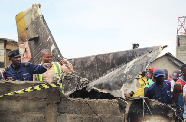 Rescuers and onlookers gather amidst the debris of an aircraft operated by private carrier Busy Bee which crashed in Goma, Congo on Nov. 24, 2019. (Justin Kabumba/AP Photo)