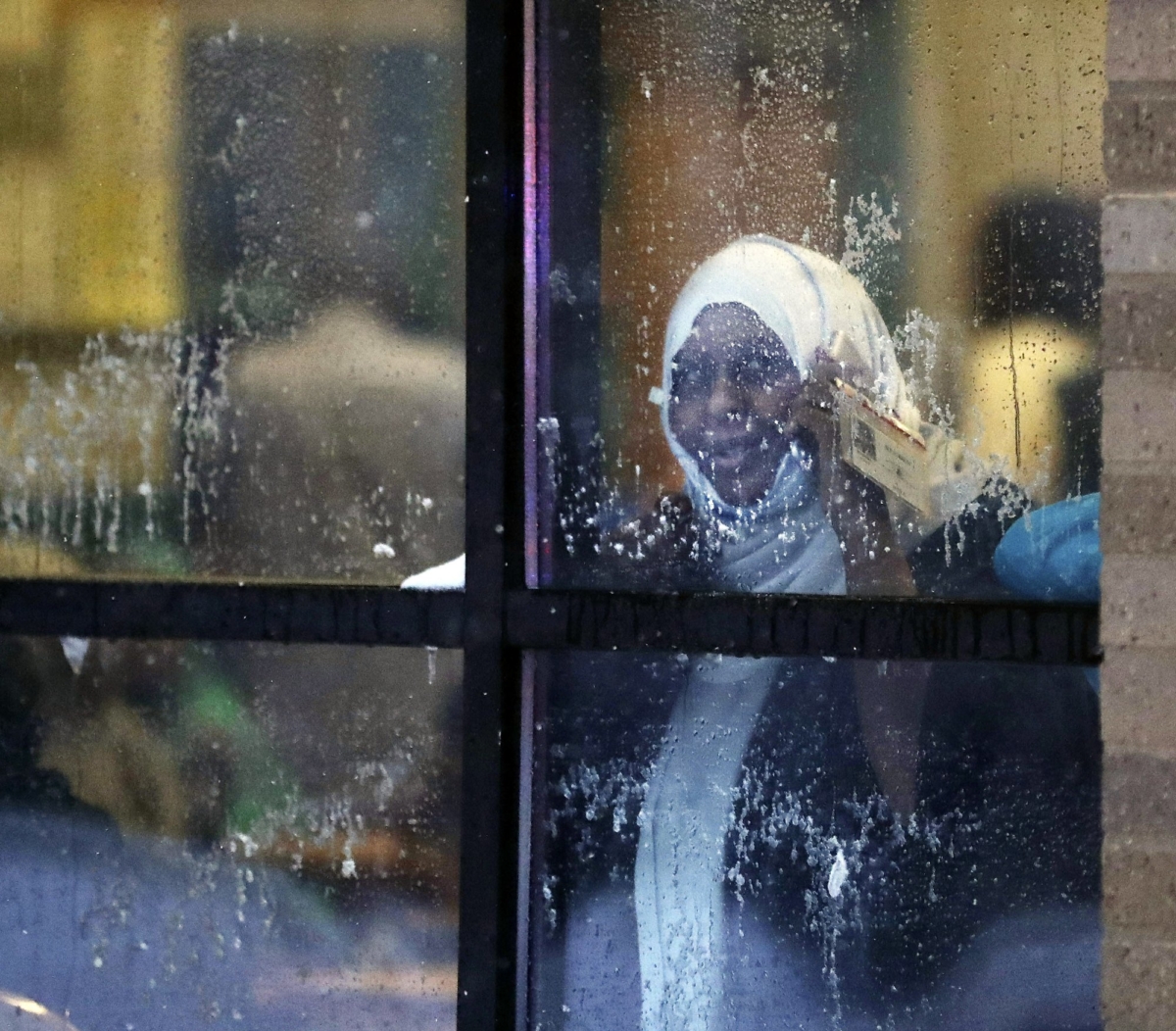 A displaced resident looks out a window after a deadly fire at a high-rise apartment building on Nov. 27, 2019, in Minneapolis. (David Joles/Star Tribune via AP)