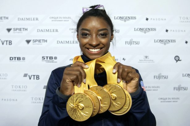 Simone Biles of the United States shows her five gold medals won at the Gymnastics World Championships in Stuttgart, Germany on Oct. 13, 2019. (Marijan Murat/dpa via AP-File)