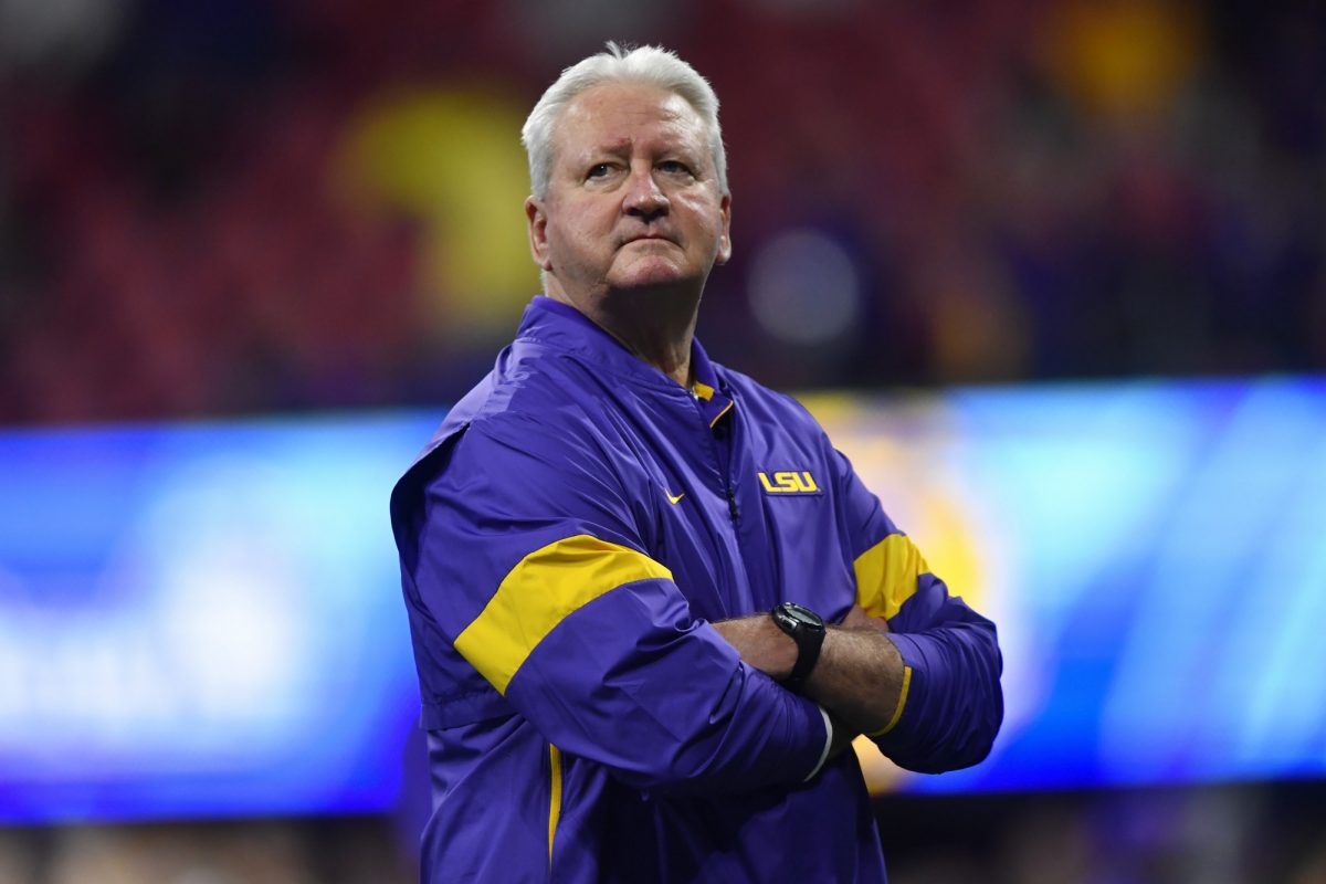 LSU Offensive Coordinator Steve Ensminger watches teams warm up before the first half of the Peach Bowl NCAA semifinal college football playoff game between LSU and Oklahoma, Saturday, Dec. 28, 2019, in Atlanta (John Amis/Associated Press)