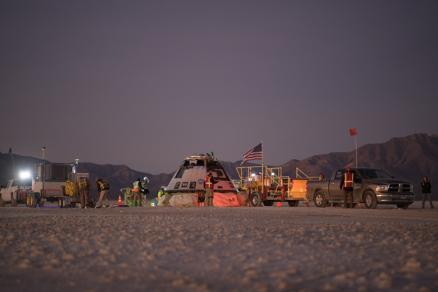 Boeing, NASA, and U.S. Army personnel work around the Boeing Starliner spacecraft shortly after it landed in White Sands, N.M., on Dec. 22, 2019. (Bill Ingalls/NASA via AP)