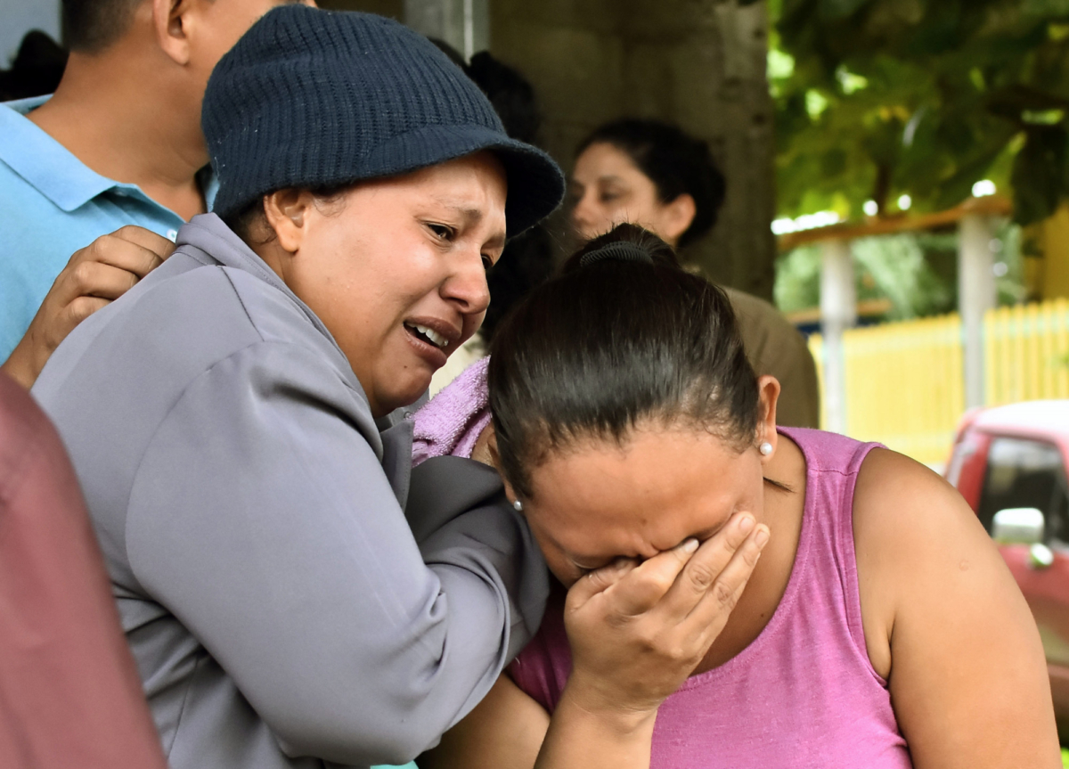 Relatives of inmates react after getting information about their loved ones in front of the penitentiary of Tela, Atlantida department, Honduras, on Dec. 21, 2019, following clashes ocurred at the jail. (Photo by STR/AFP via Getty Images)