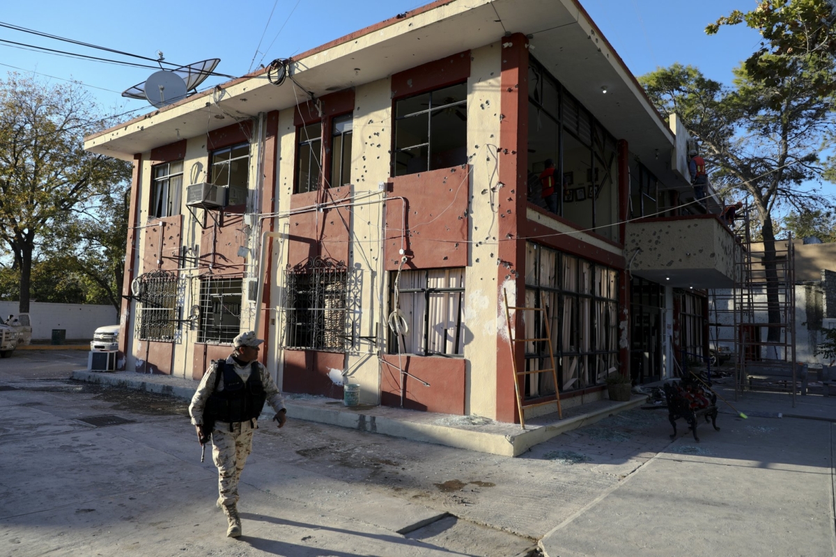 A soldier walks past City Hall that is riddled with bullet holes, in Villa Union, Mexico, on Dec. 2, 2019. (Eduardo Verdugo/AP Photo)