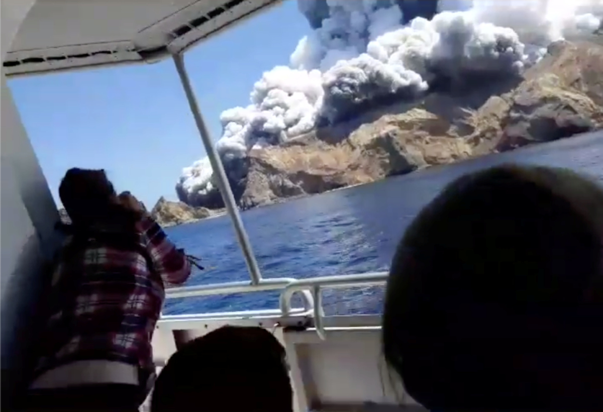 People on a boat react as smoke billows from the volcanic eruption of Whakaari, also known as White Island, New Zealand on Dec. 9, 2019 in this picture grab obtained from a social media video. (INSTAGRAM @ALLESSANDROKAUFFMANN/via Reuters)