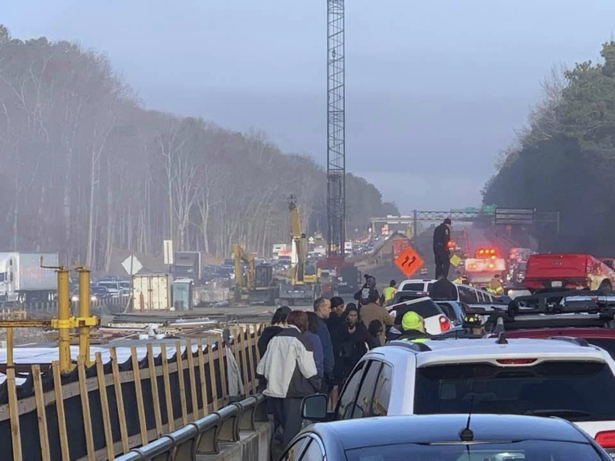Drivers and emergency personnel remain on the scene of a multi-vehicle pileup on Interstate 64 in York County, Va., Sunday, Dec. 22, 2019. (Ivan Levy via AP)