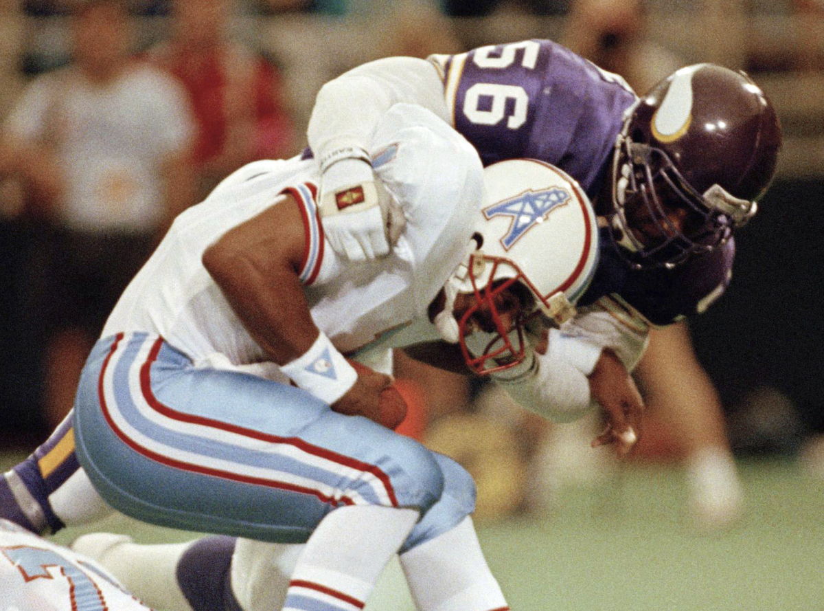 Minnesota Vikings linebacker Chris Doleman (56) brings down Houston Oilers quarterback Warren Moon for a safety during preseason NFL football action in Minneapolis on Aug. 27, 1990. (Jim Mone/AP Photo)