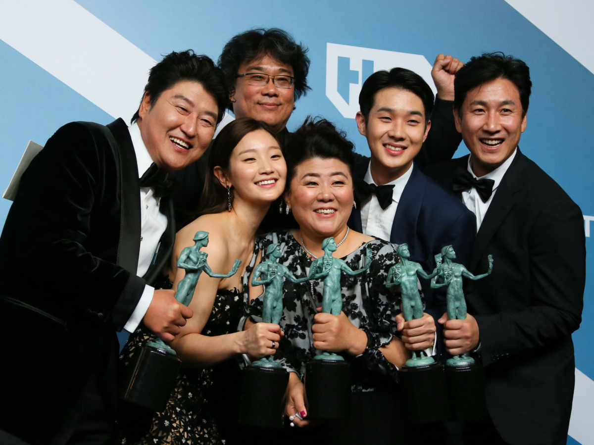 "Parasite" cast (L-R) Song Kang-ho, Cho Yeo-jeong, director Bong Joon-ho, Lee Jung-eun, Choi Woo-shik, and Lee Sun-kyun pose with the trophy for Outstanding Performance by a Cast in a Motion Picture in the press room during the 26th Annual Screen Actors Guild Awards at the Shrine Auditorium, in Los Angeles, on Jan. 19, 2020. (Jean-Baptiste Lacroix /AFP via Getty Images)