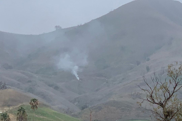 Smoke rises amid foggy weather from the site of a helicopter crash that killed former NBA star Kobe Bryant, his daughter Gianna, and seven others, along a hillside in Calabasas, Calif., on Jan. 26, 2020. (INSTAGRAM/@PRINCESSOFCALABASAS via Reuters)