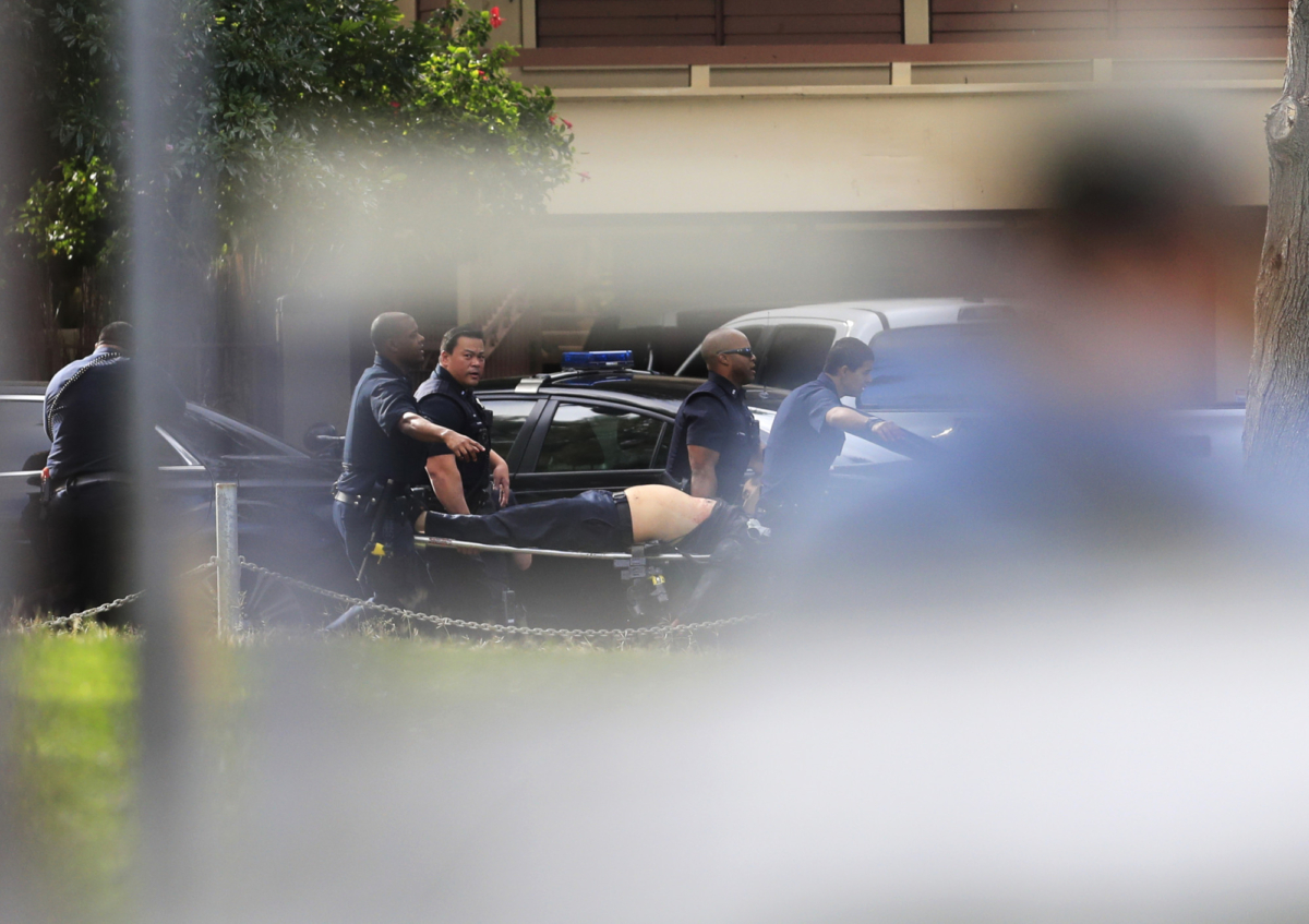 Honolulu police carry an injured fellow officer after a shooting and domestic incident at a residence on Hibiscus Road near Diamond Head in Honolulu, Hawaii, on Jan. 19, 2020. (Jamm Aquino/Honolulu Star-Advertiser).