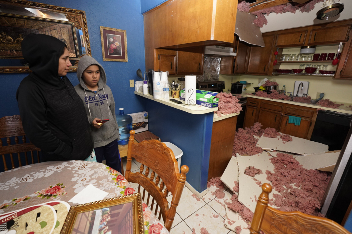 Maria Hernandez and her son, Alejandro Ambriz, 10, stand by the kitchen where the ceiling collapsed in their home, just one street east where an explosion occurred on Jan. 24, 2020 in Houston.(Melissa Phillip/Houston Chronicle via AP)