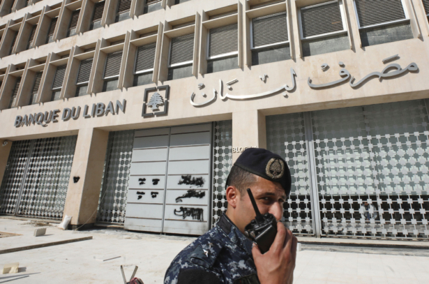 A member of the Lebanese security forces stands at the entrance of the Central Bank after anti-government protesters broke down a construction barrier as they rally at the same time of a press conference held by the bank's governor in Beirut, Lebanon, on Nov. 11, 2019. (Anwar Amro/AFP via Getty Images)