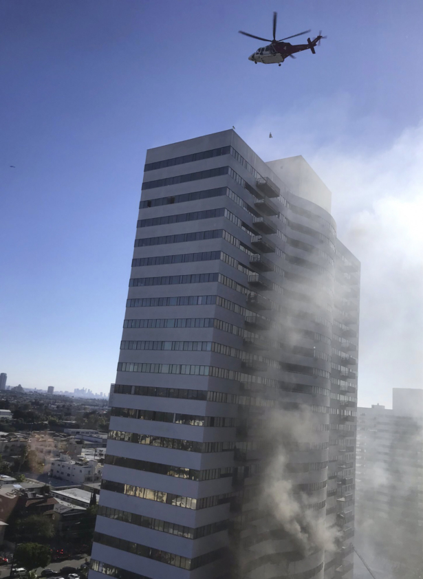 A helicopter flies over a residential building that is on fire in Los Angeles, on Jan. 29, 2020. (Megan Feldman via AP)