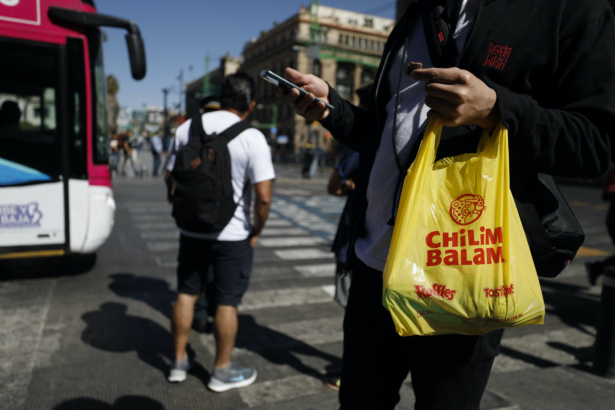 A young man carries a new plastic bag, suddenly a rare sight on the streets of the capital as a ban on plastic bags took effect with the new year, in Mexico City, Wednesday, Jan. 1, 2020. (Rebecca Blackwell/AP)