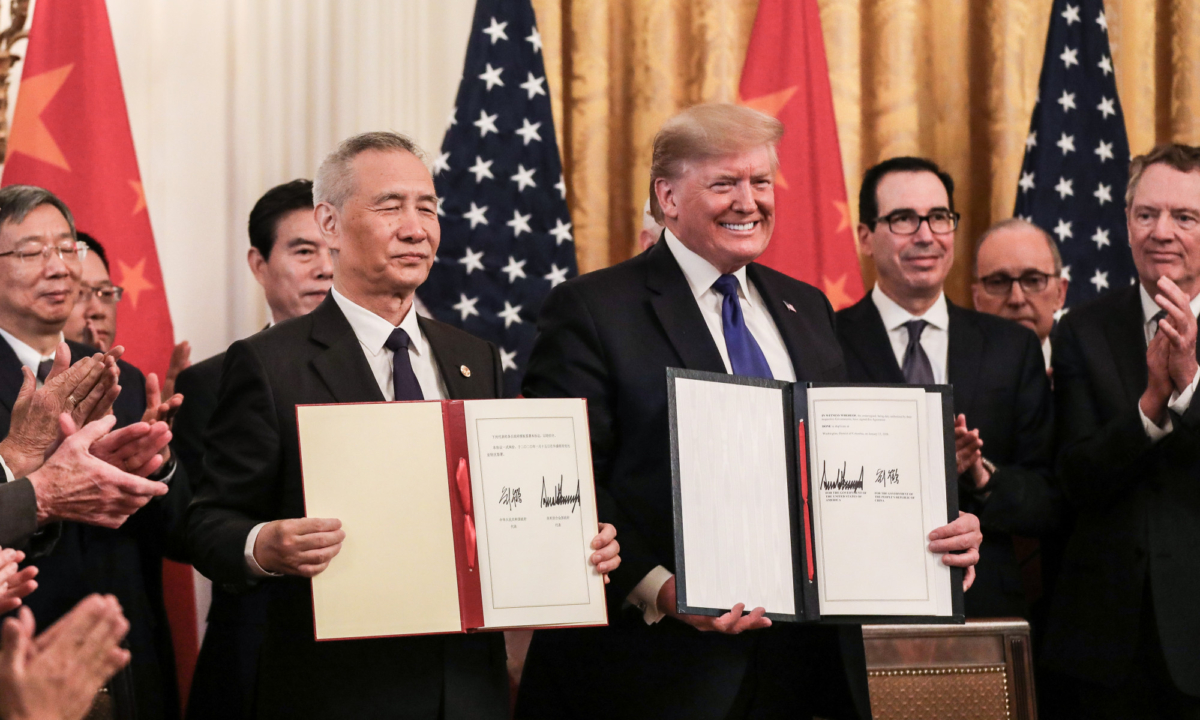 Chinese Vice Premier Liu He (L) and President Donald Trump during the signing of phase one of a trade deal, surrounded by officials, in the East Room of the White House in Washington on Jan. 15, 2020. (Charlotte Cuthbertson/The Epoch Times)