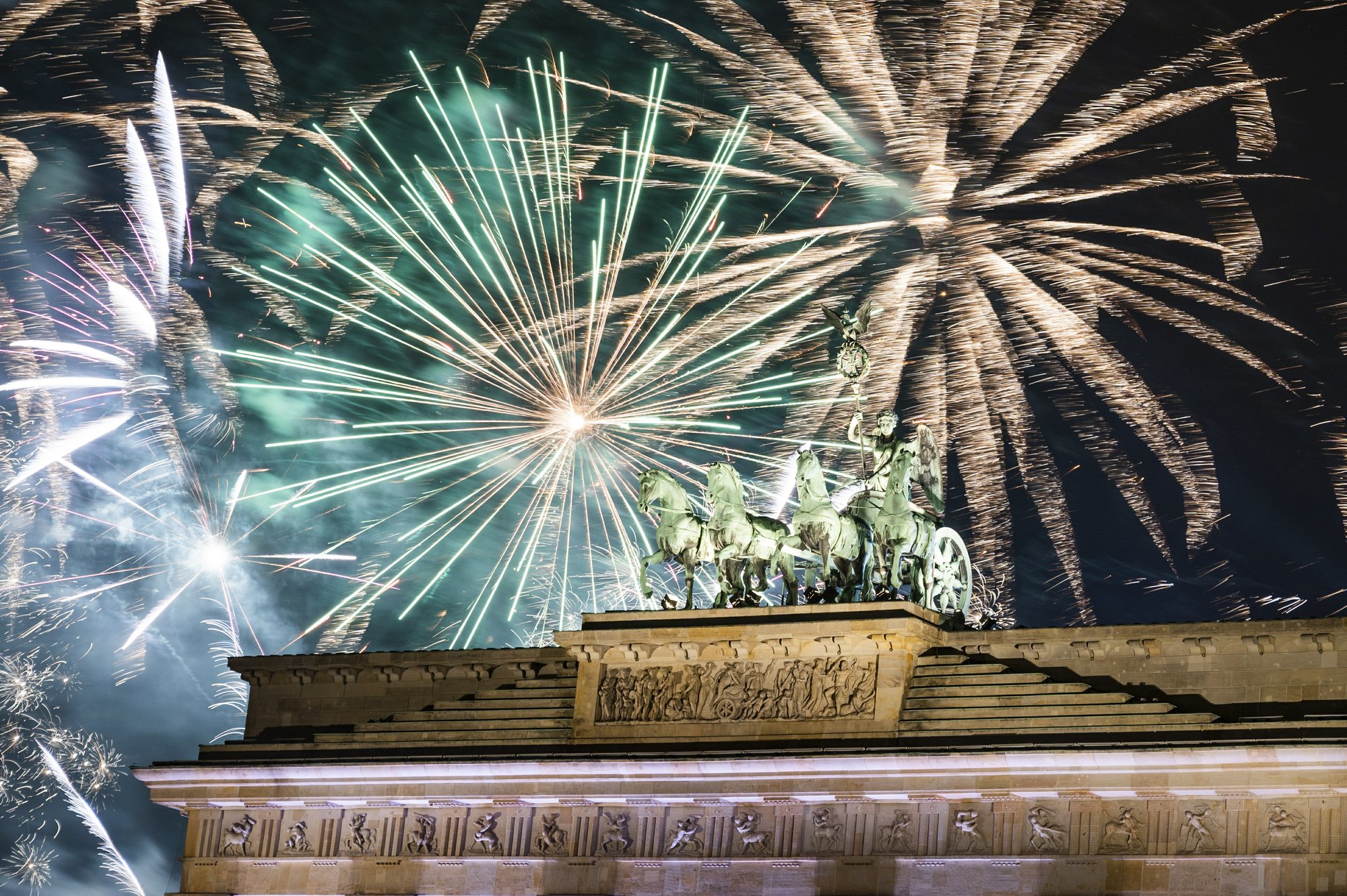 Fireworks light the sky above the Quadriga at the Brandenburg Gate during New Year celebrations in Berlin, Germany on Jan. 1, 2020. (Christophe Gateau/dpa via AP)
