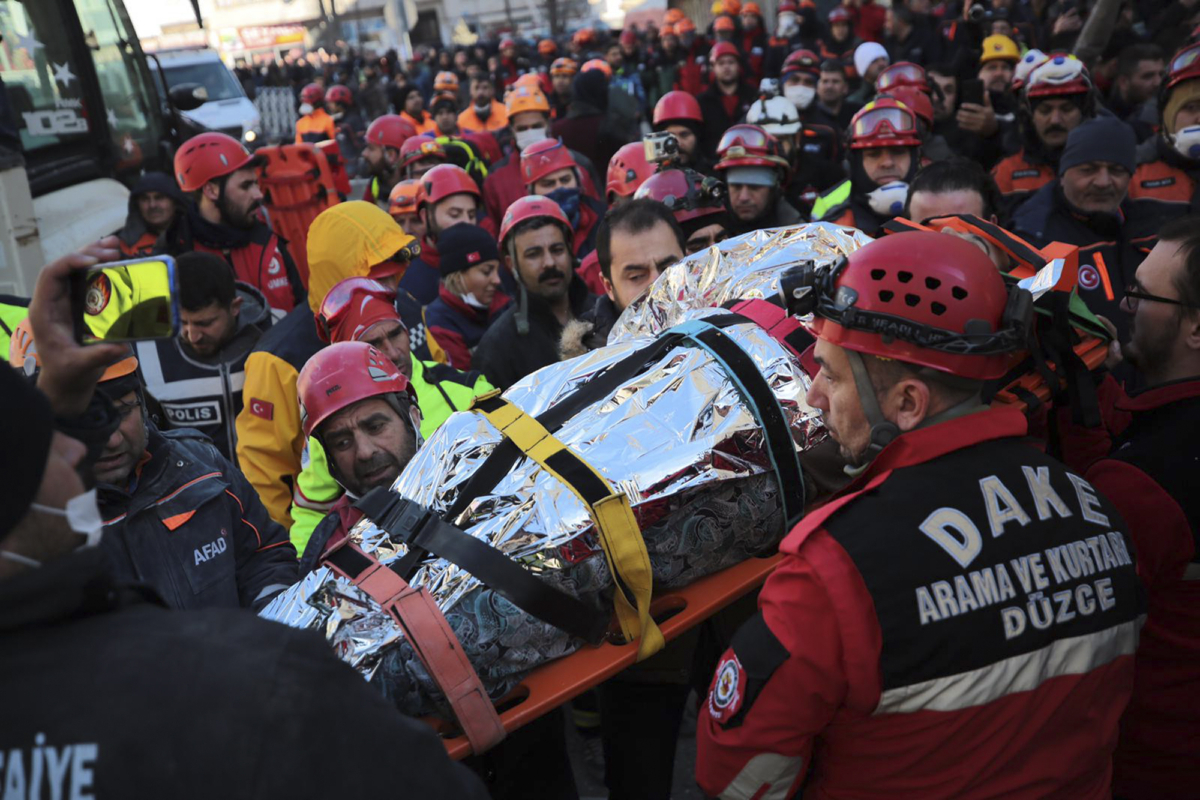 Members of rescue services carry a wounded man, that was found in the rubble of a building destroyed on Friday's earthquake in Elazig, eastern Turkey, on Jan. 25, 2020. (IHH/ Humanitarian Relief Foundation via AP)