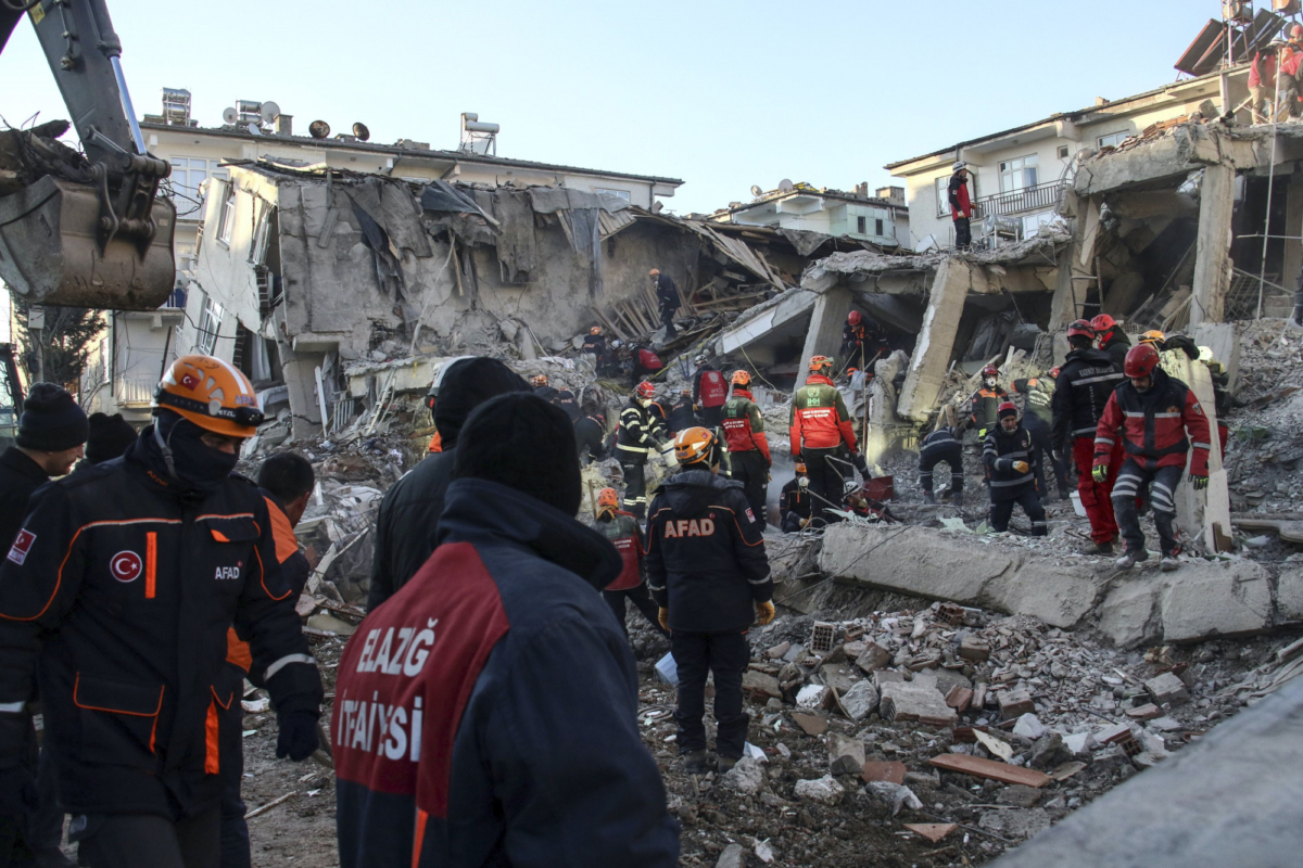 Rescue workers try to save people trapped under debris following a strong earthquake that destroyed several buildings on Friday, in Elazig, eastern Turkey, on Jan. 26, 2020.(Ismail Coskun/IHA via AP)