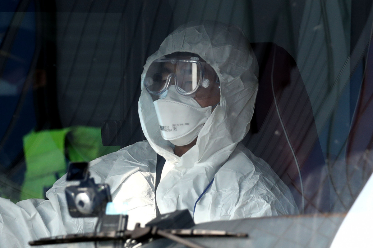A South Korean rescue member sits in an ambulance carrying a South Korea citizen repatriated from Wuhan, China, who has shown flu-like symptoms during in-flight screening for novel coronavirus leaves Gimpo airport in Seoul, South Korea on Jan. 31, 2020. (Chung Sung-Jun/Getty Images)