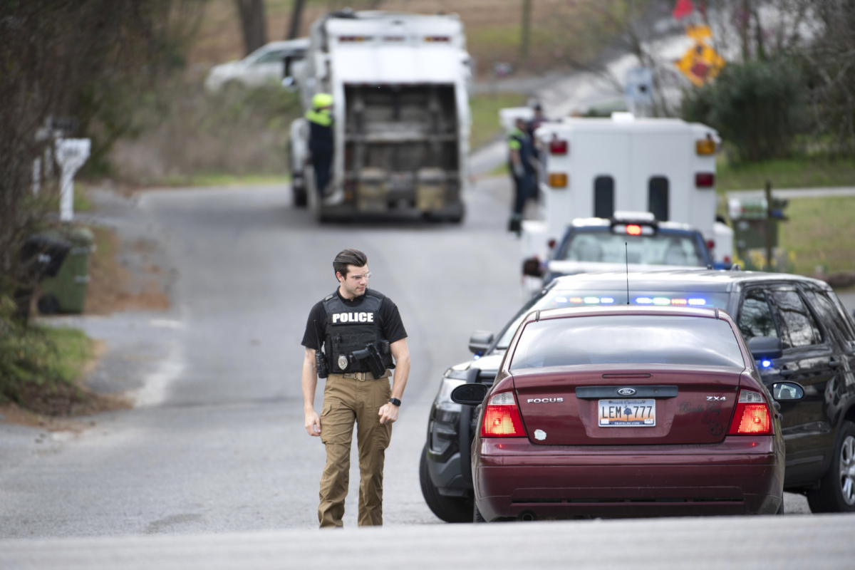 A Cayce police officer approaches a vehicle at a road block near an entrance to the Churchill Heights neighborhood on Feb. 13, 2020, in Cayce, S.C., where six year-old Faye Marie Swetlik recently went missing. (Sean Rayford/AP Photo)