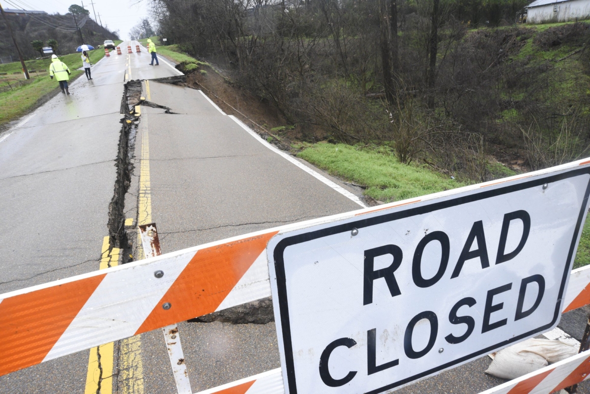Mississippi Department of Transportation personnel is seen on scene where part of the roadway of Highway 80 has washed away just near Mount Alban Road in Vicksburg, Miss., on Feb. 11, 2020. (Courtland Wells/The Vicksburg Post via AP)