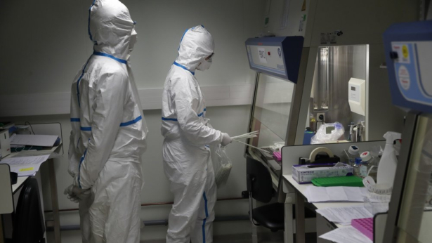 French lab scientists in hazmat gear inserting liquid in test tube manipulate potentially infected patient samples at Pasteur Institute in Paris, on Feb. 6, 2020. (Francois Mori/AP Photo)