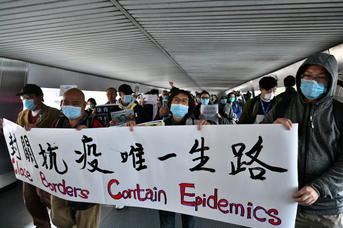 Protesters hold up banners and placards during a "flash mob" gathering to demand the government close its border with mainland China to reduce the spread of the deadly SARS-like virus to Hong Kong on Feb. 3, 2020. (Anthony Wallace/AFP via Getty Images)