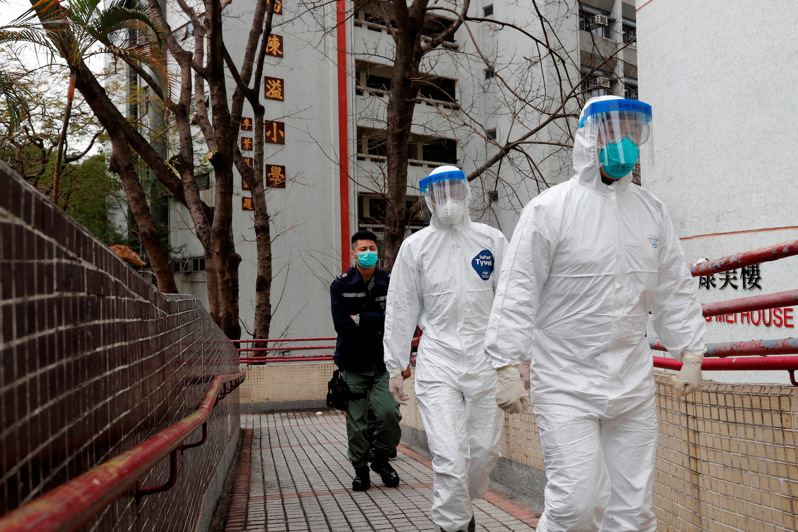 Health workers in protective gears walk as they evacuate residents from a public housing building, following the outbreak of the Novel Coronavirus, outside Hong Mei House, at Cheung Hong Estate in Hong Kong, China, on Feb. 11, 2020. (Tyrone Siu/Reuters)