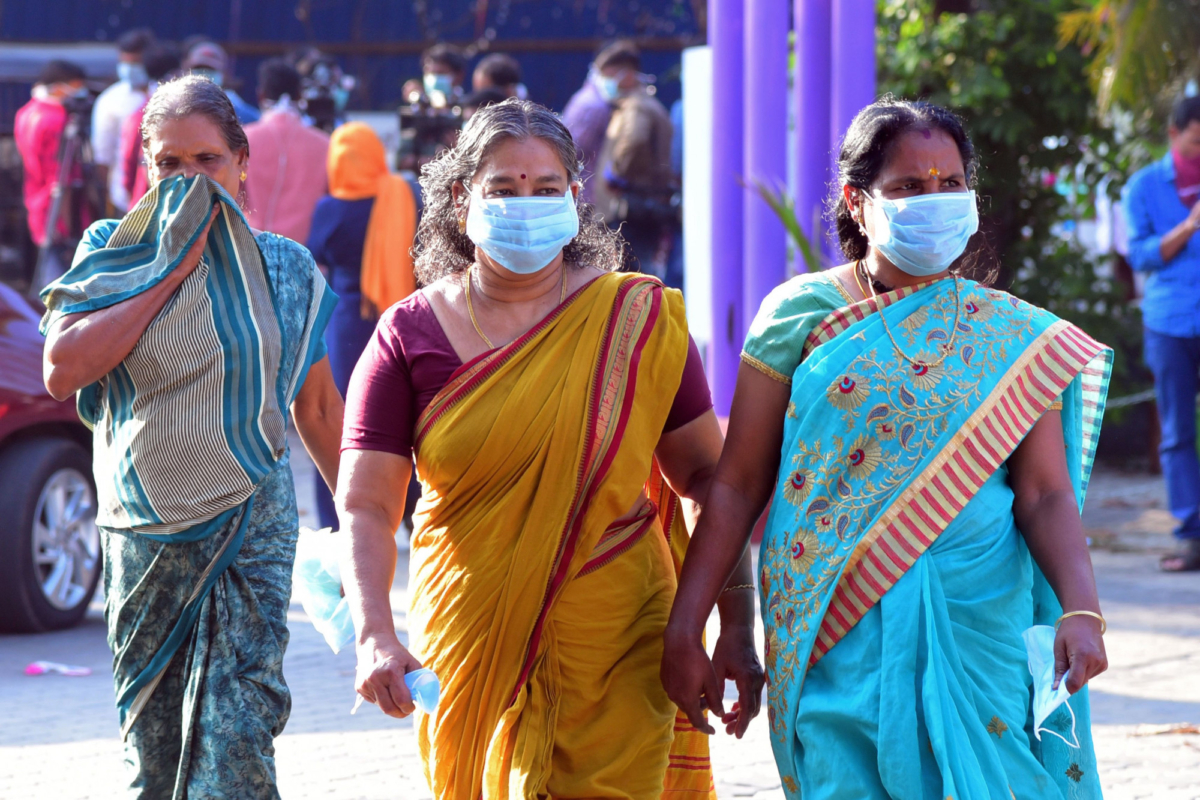 Residents and hospital visitors wearing facemaks walk outside the Government Medical College in Thrissur on Jan. 30, 2020, where the first confirmed case of the SARS-like virus in India is kept in isolation. (AFP via Getty Images)