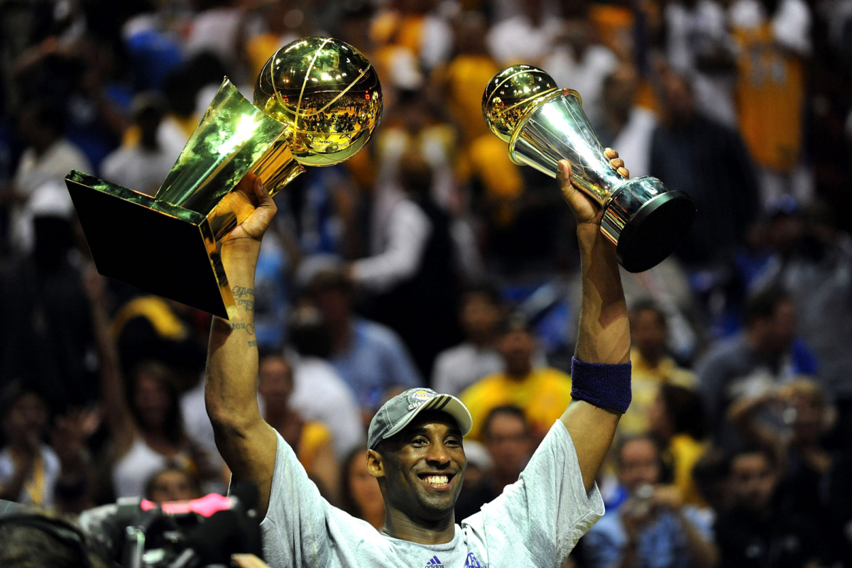 Kobe Bryant #24 of the Los Angeles Lakers holds up the Larry O'Brien trophy and the Bill Russell MVP trophy after the Lakers defeated the Orlando Magic 99-86 in Game Five of the 2009 NBA Finals at Amway Arena in Orlando, Fla., on June 14, 2009. (Ronald Martinez/Getty Images)