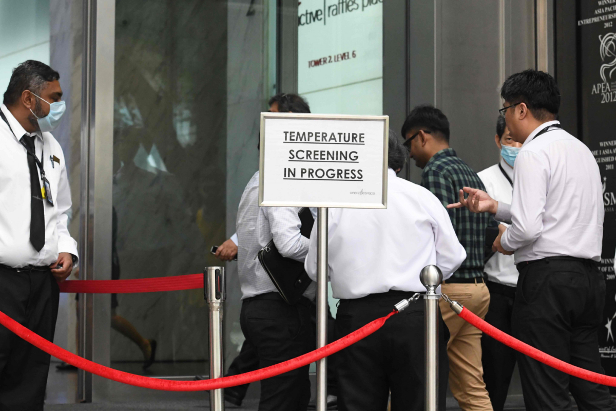 Building management staff conduct temperature screenings of visitors and tenants of a building in the financial district of Singapore on Feb. 10, 2020. (Roslan Rahman/AFP via Getty Images)