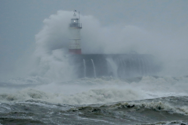 Waves crash over the harbor and a lighthouse, as Storm Ciara hits Newhaven, on the south coast of England, on Sunday, Feb. 9, 2020. (Matt Dunham/AP Photo)