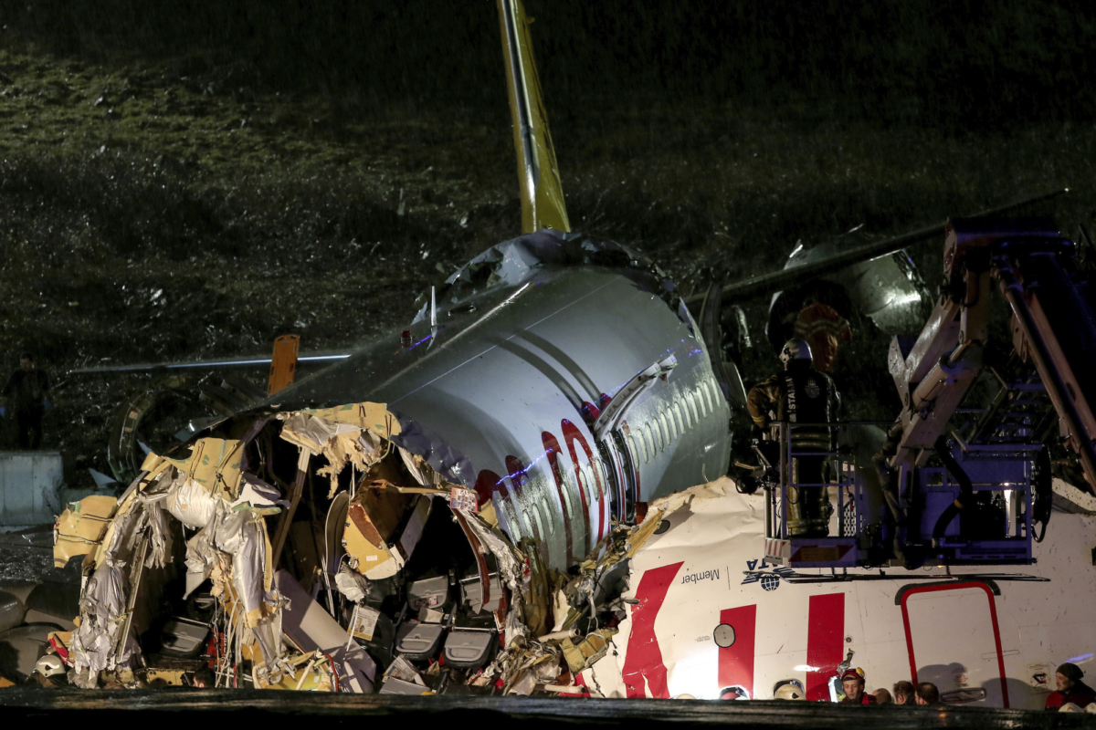 Rescue members and firefighters work after a plane skidded off the runway at Istanbul's Sabiha Gokcen Airport, Istanbul, Turkey, on Feb. 5, 2020. (Can Erok/DHA via AP)