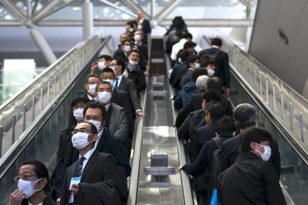 People wearing face masks ride escalators in Tokyo, Japan, on Feb. 13, 2020. (Tomohiro Ohsumi/Getty Images)