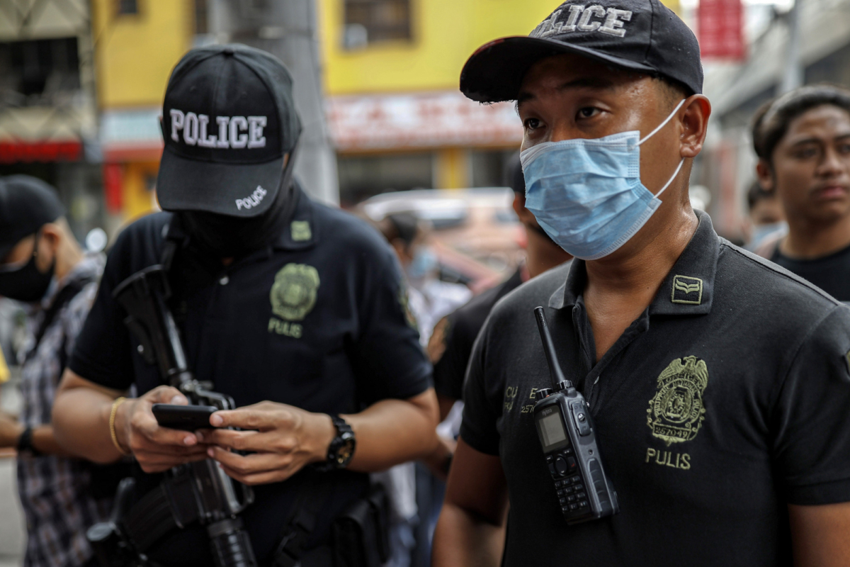 Police officers stand guard outside a medical supply shop that was raided by police for allegedly hoarding and overpricing the masks, as public fear over China's Wuhan Coronavirus grows in Manila, Philippines, on Jan. 31, 2020. (Ezra Acayan/Getty Images)