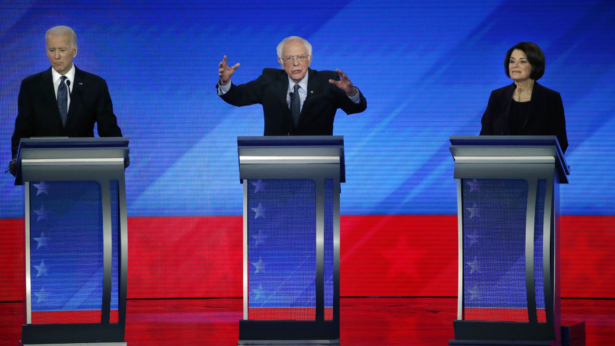 Democratic presidential candidate Sen. Bernie Sanders (I-Vt.), center, speaks at former Vice President Joe Biden, left, and Sen. Amy Klobuchar (D-Minn.) listen during the Democratic presidential debate in Manchester, New Hampshire on Feb.7, 2020. (Elise Amendola/AP Photo)