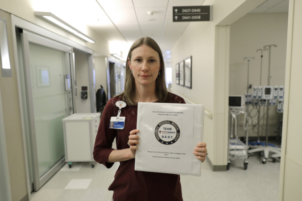 Sarah Wilkerson, manager of infection prevention at Providence Regional Medical Center, poses for a photo holding a binder of policies and procedures for treating highly infectious patients in Everett, Wash., on Jan. 23, 2020. (Ted S. Warren/AP)