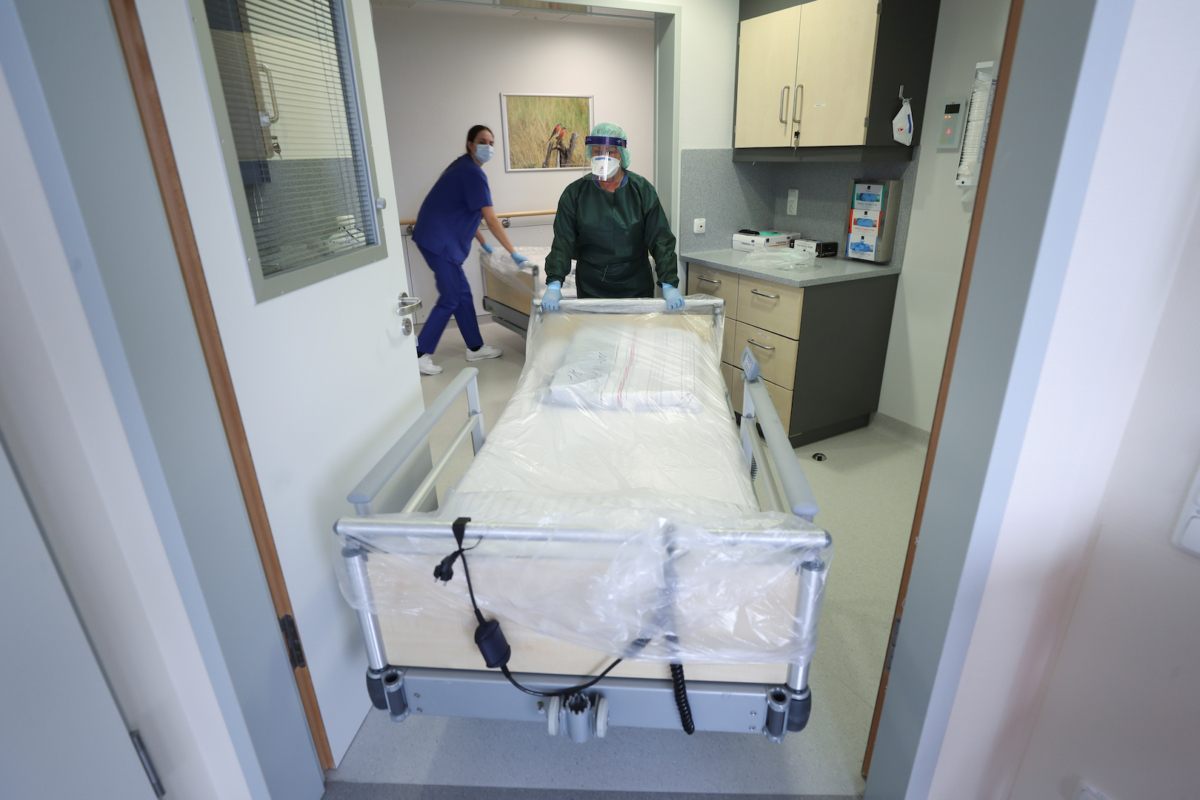 Canan Emcan, 31, chief nurse of the infection and virologist ward of the university clinic of Essen pushes a clean hospital bed into a special sick room to be used in case of coronavirus patients during a media event in Essen, Germany, on March 5, 2020. (Wolfgang Rattay/Reuters)