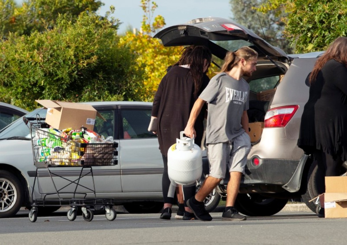 People take out products from their supermarket shopping cart and load them into their car outside Pak'nSave supermarket amid the spread of the coronavirus disease (COVID-19) in Christchurch, New Zealand, on March 23, 2020. (Martin Hunter/Reuters)