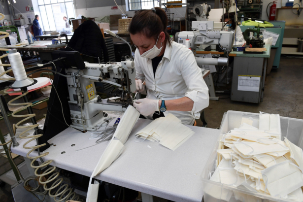 An employee wearing a face mask sews surgical masks at a leather workshop turned into a mask factory, close to Vigevano, Lombardy, Italy, on March 19, 2020. (Miguel Medina/AFP via Getty Images)