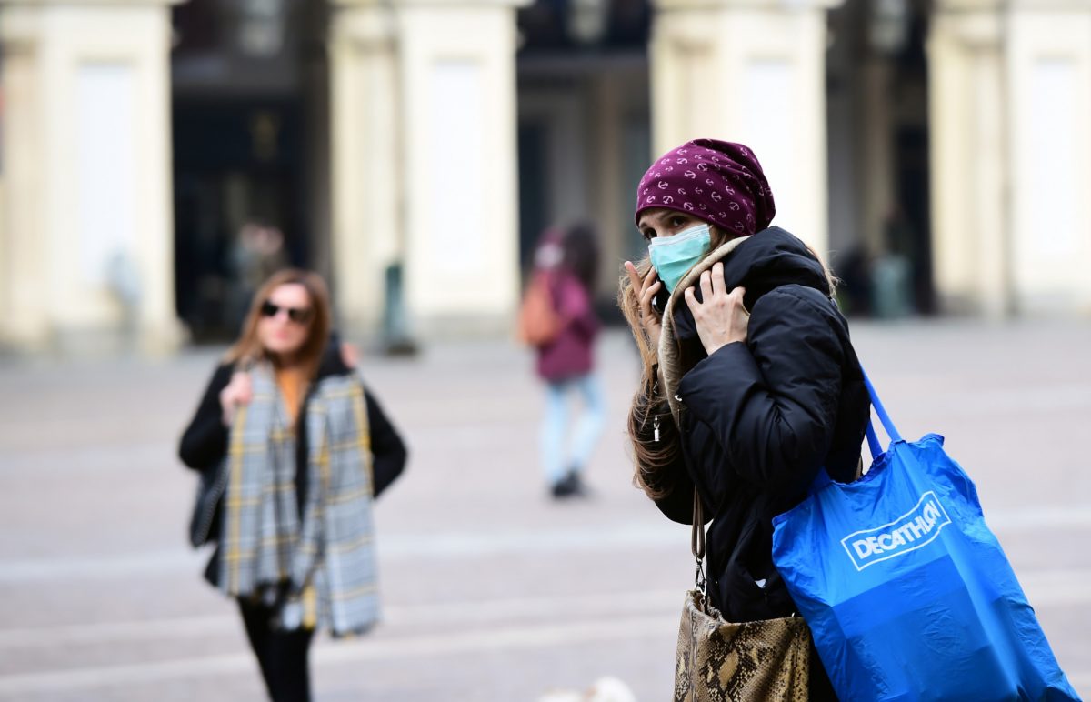A woman wearing a protective face mask walks in the streets after the government decree to close cinemas, schools and urge people to work from home and not stand closer than one metre to each other, in Turin, Italy on March 5, 2020. (Massimo Pinca/Reuters)